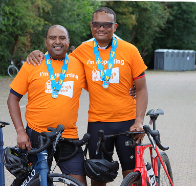 Two cyclists wearing event T‑shirts and medals stand with their bikes after taking part in Cycle for Life to raise vital funds for Farleigh Hospice.