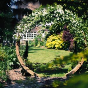 A view of a circular framework covered in flowers in a decorative garden