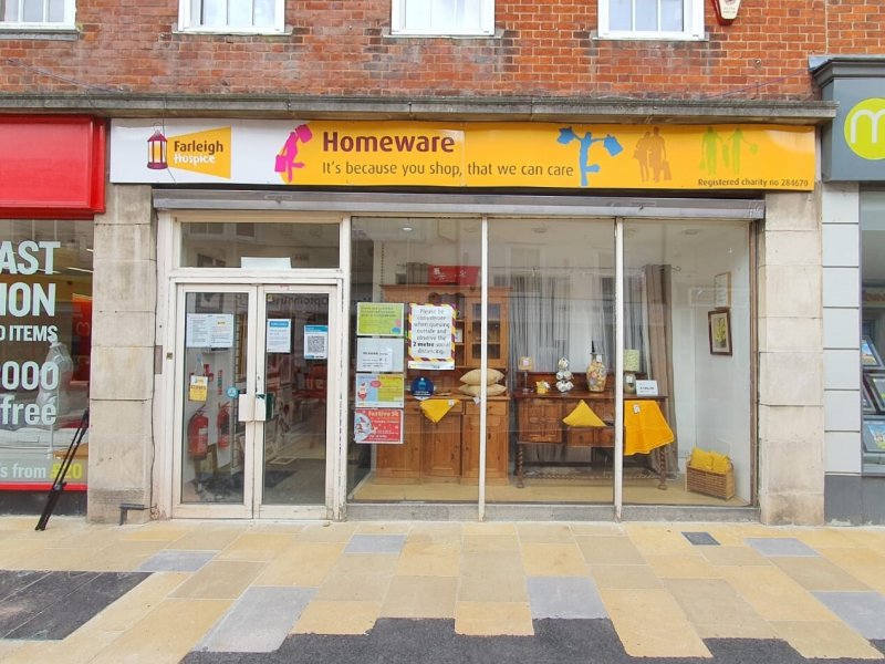 A charity homeware shop displaying a bright yellow sign that reads 
