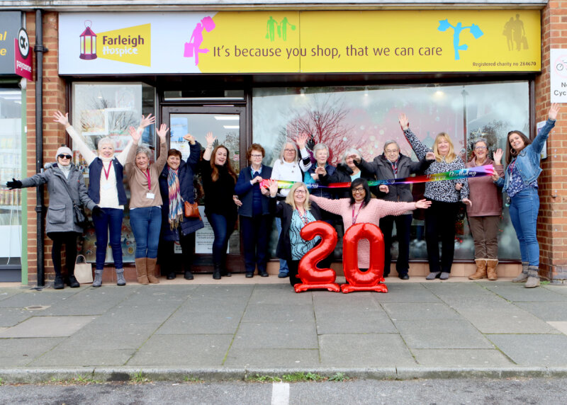 Group of people celebrating outside a Farleigh Hospice shop with red 