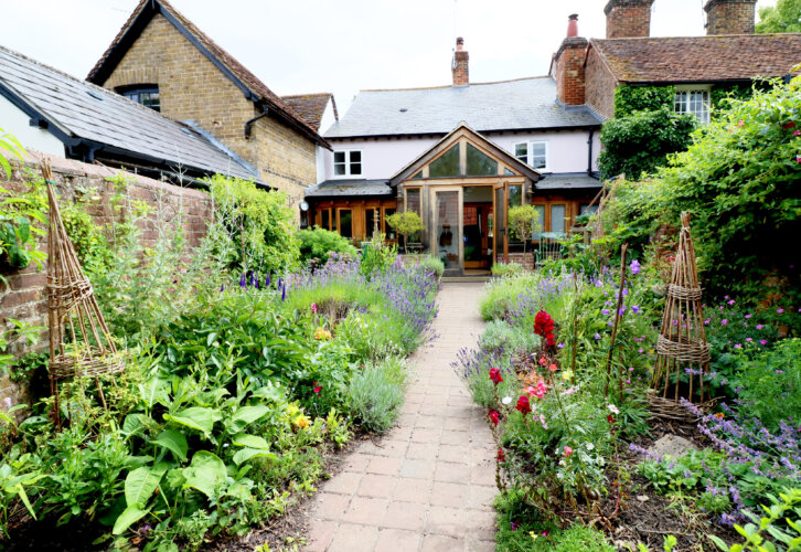 A cottage garden with stone path and summer flowers