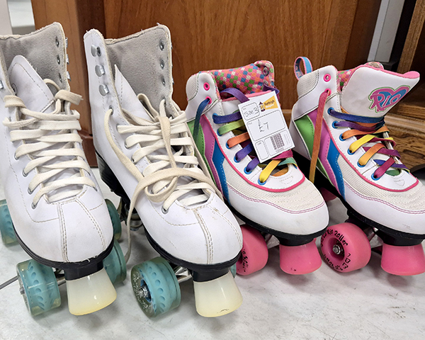 Two pairs of white roller skates with colourful laces