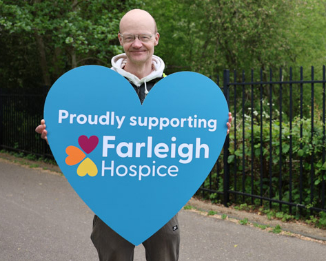 Volunteer John Spillane holds up a large heart printed with the words 'Proudly supporting Farleigh Hospice' at the Walk for Life event