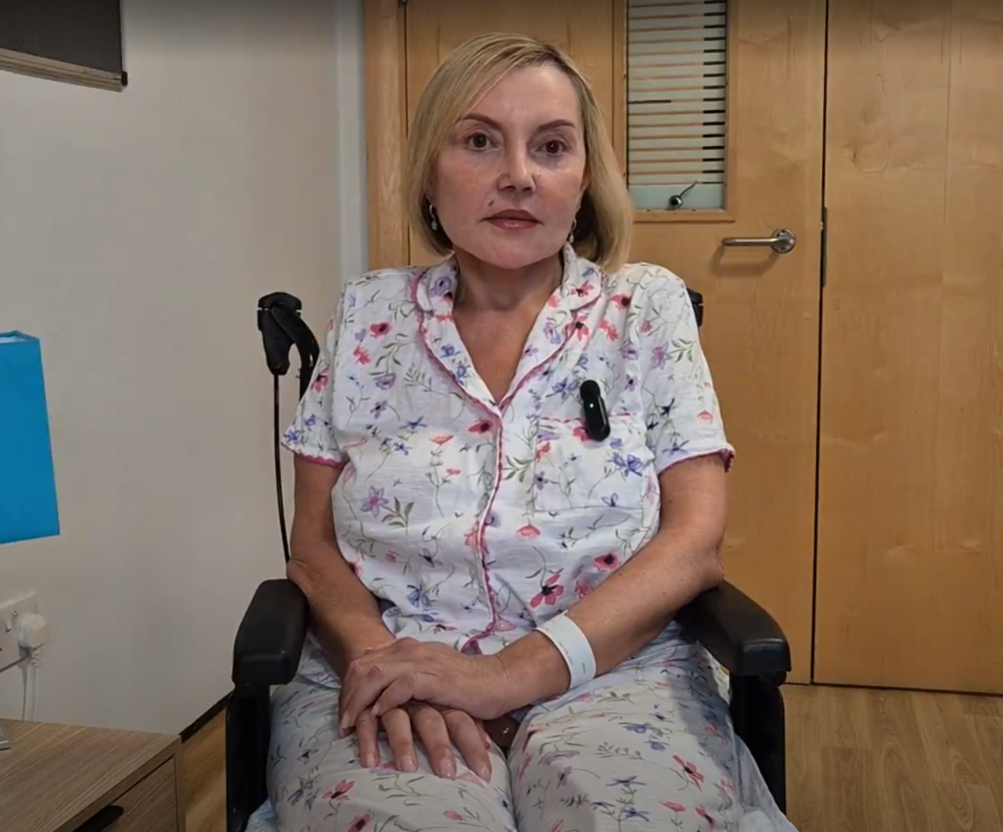 A Farleigh Hospice patient named Joanne, who is living with motor neurone disease, sits in a wheelchair in the Farleigh Hospice Inpatient Unit. She is sharing her experience of care at Farleigh.